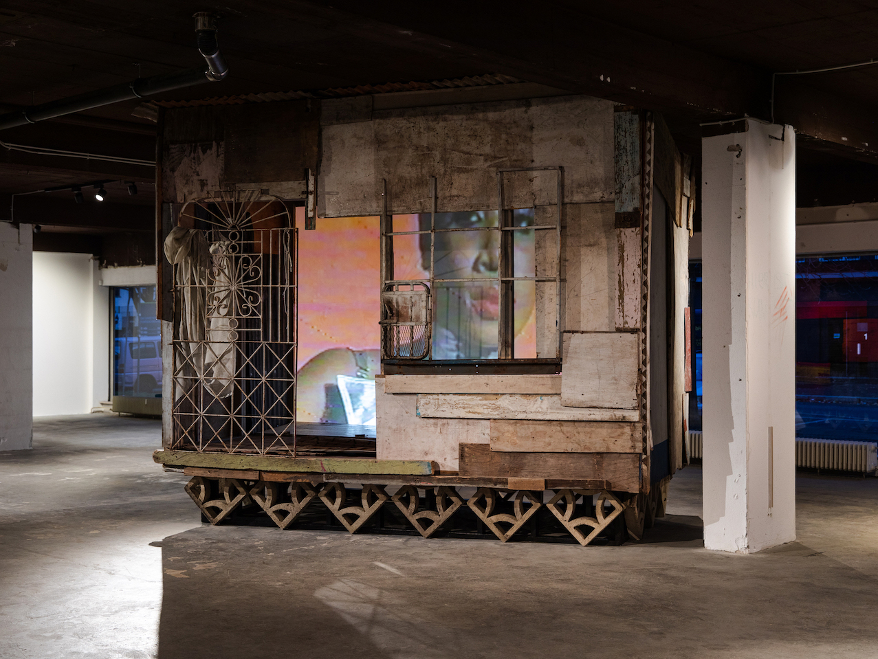Akeem Smith, Installation view, "Queens Street", Single-channel video, salvaged building material and fabric, breeze blocks, wood, Heidi, 2020